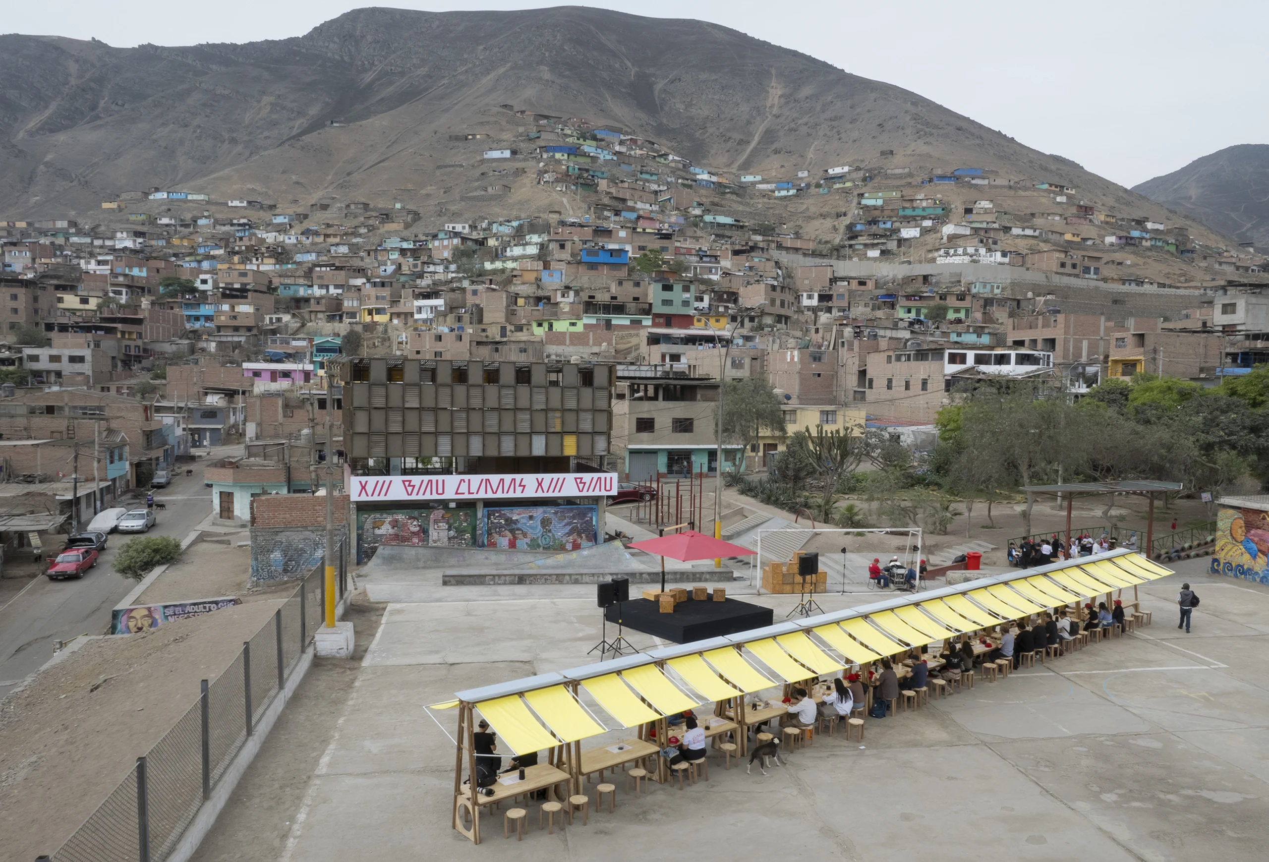 Audience and speakers under modular yellow canopy at BIAU XIII architecture event in Lima.