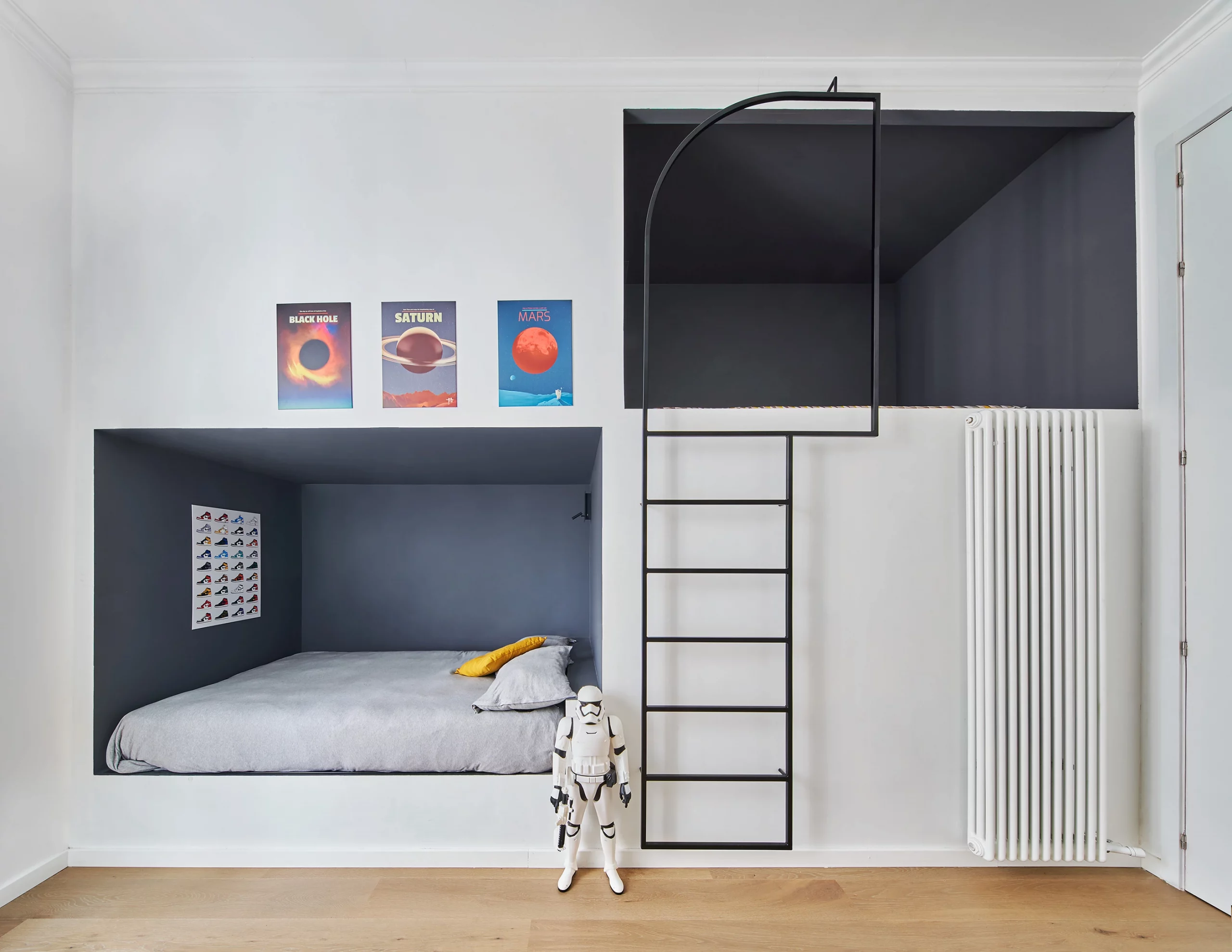 Boy’s bedroom with double-height sleeping alcoves in dark blue tones designed by Cometa Architects in Barcelona.