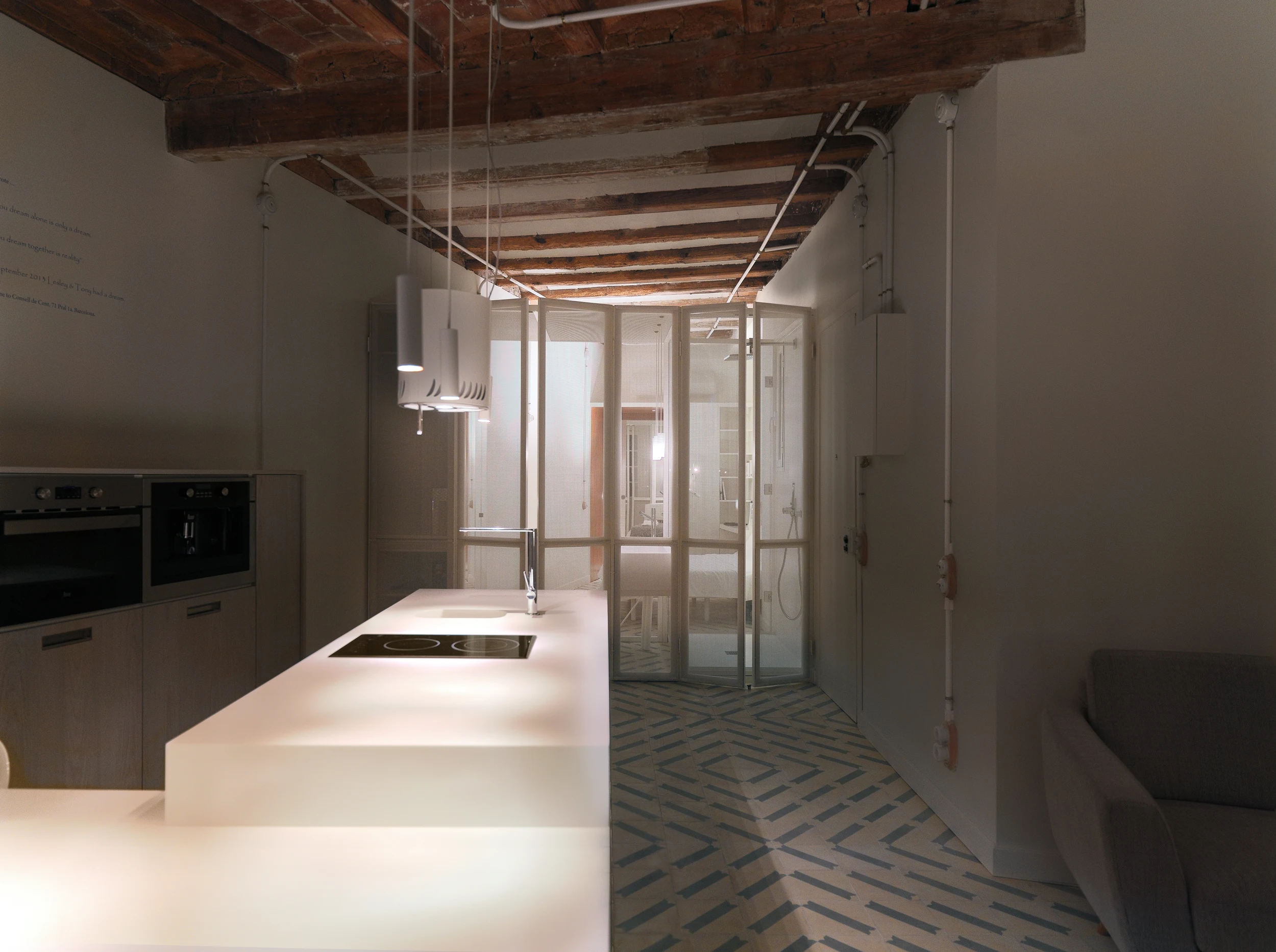 Illuminated Barcelona kitchen and light box at night in The Lightslice apartment by Cometa Architects
