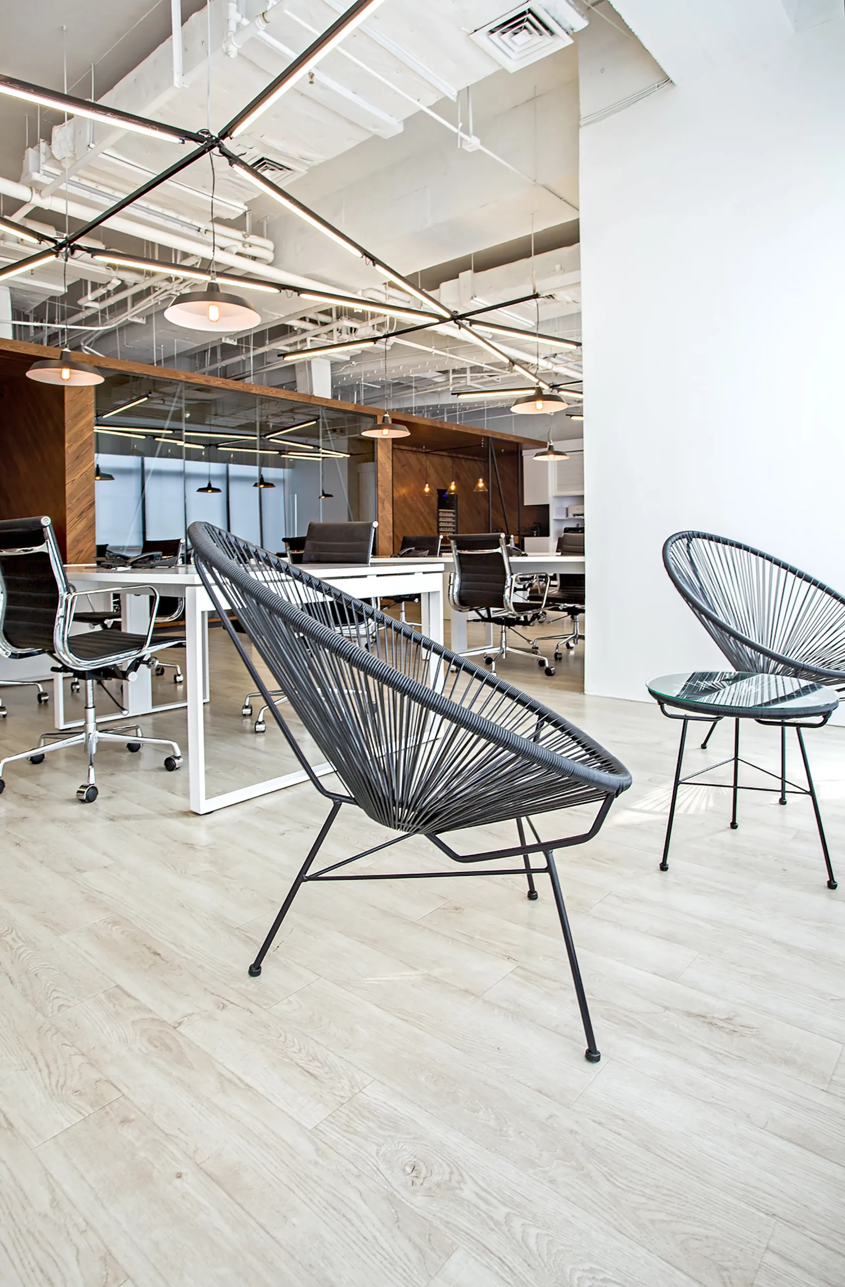 open workspace at bpo office shanghai by cometa architects with black armchairs, white desks and exposed ceiling