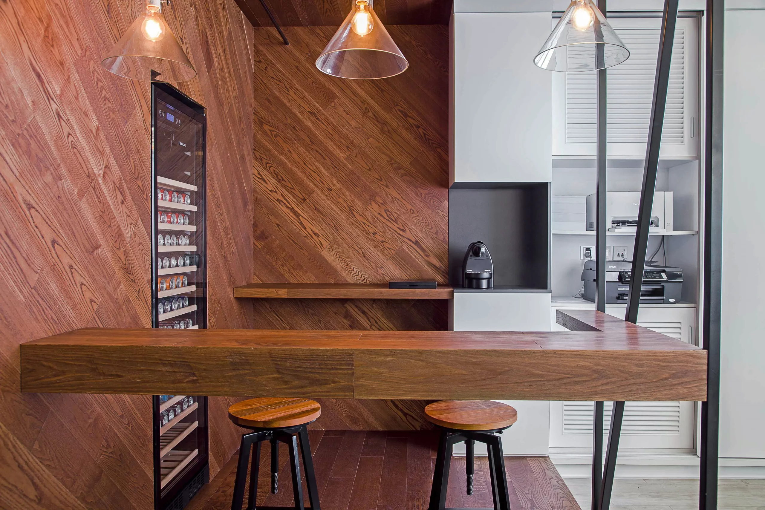 wooden break area with bar stools, diagonal wood panels and industrial lighting at bpo office shanghai by cometa architects